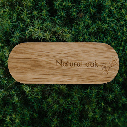 Wooden cutting board with 'Natural oak' engraving on a green moss background
